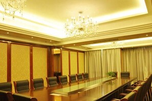 A conference room with a long table, chairs, and a chandelier. - Manhattan International Hotel (Huaibei)