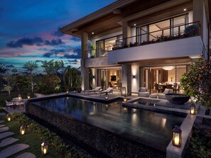 A modern two-story house with a large outdoor swimming pool, outdoor seating, and a view of the landscape. - Shangri-La Sanya (Sanya)