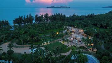 Vista aérea de un resort con playa, palmeras y piscina.