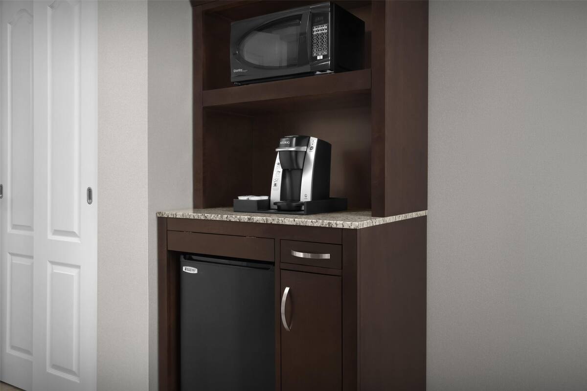 Una cocina equipada con microondas, cafetera y lavavajillas.