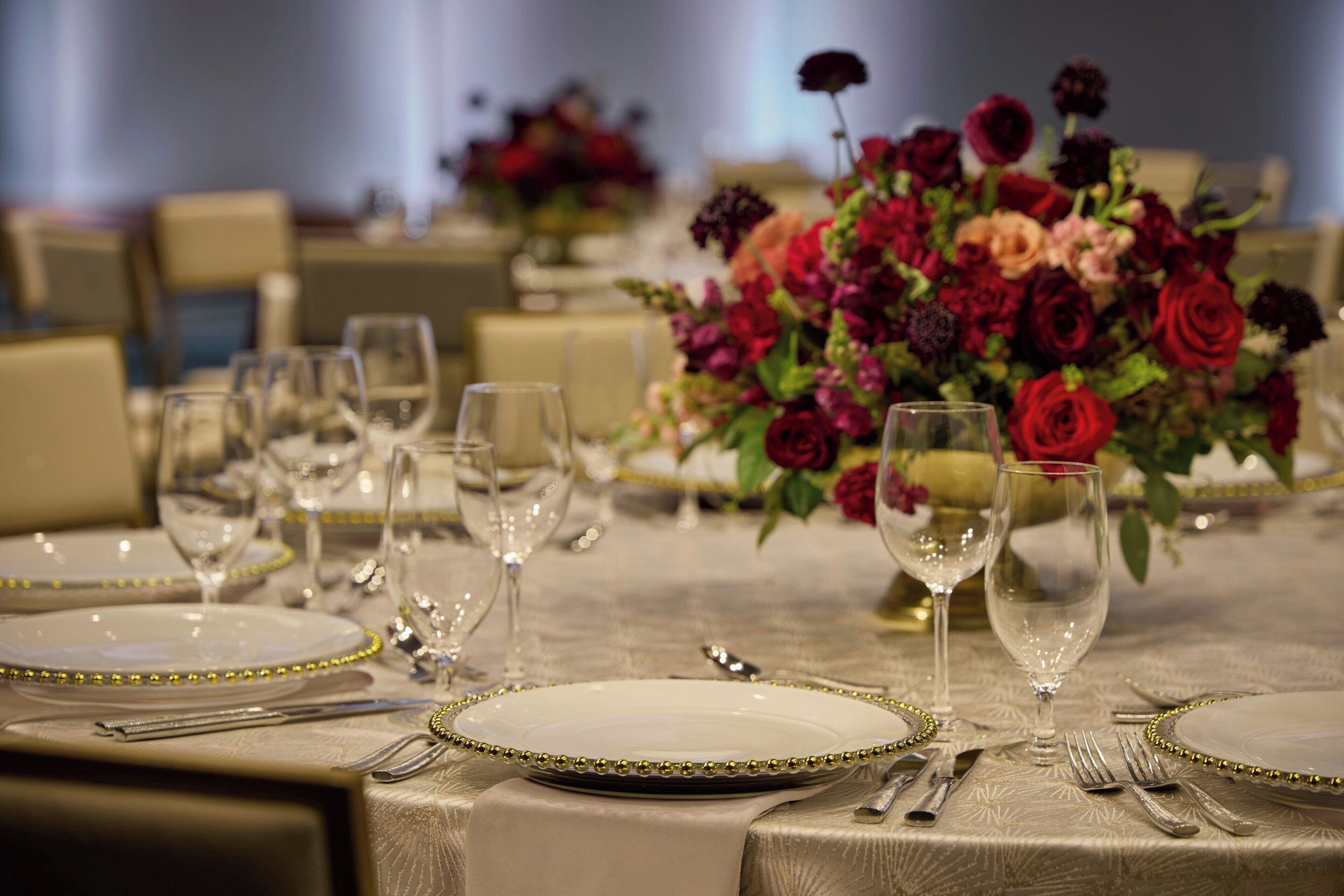 A table set for dining with plates, cutlery, and wine glasses.