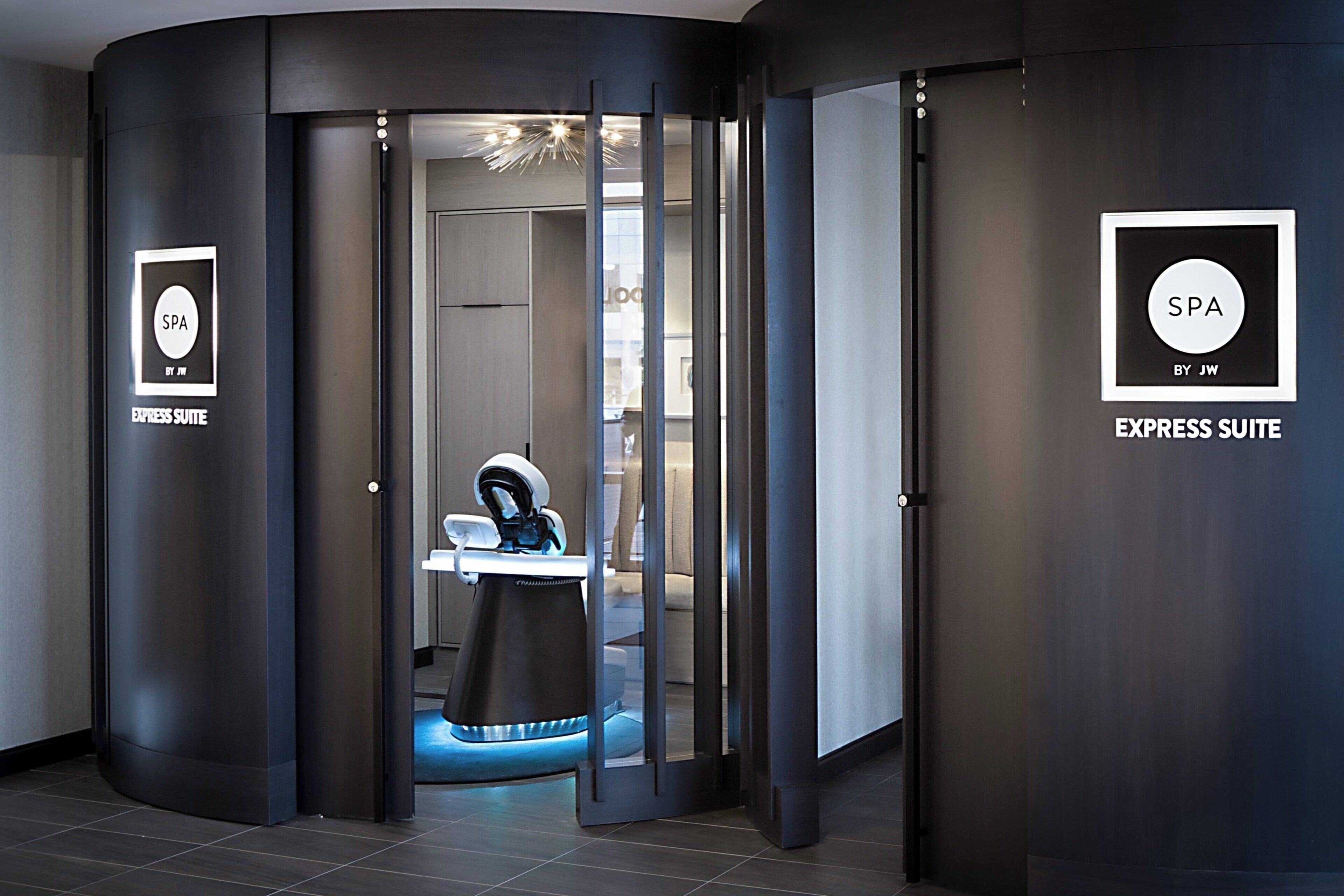 A modern spa suite with a dental chair, a sign indicating the suite name, and a door leading to the suite.