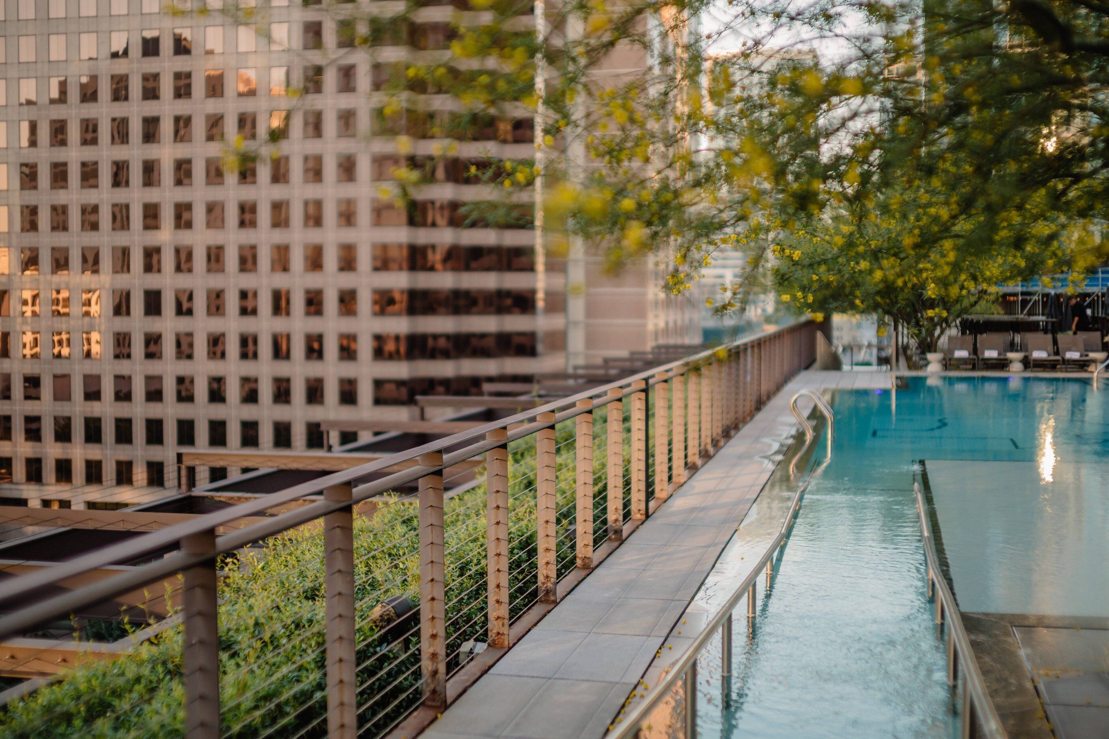 A pool area with a view of a modern building with a grid-like facade.