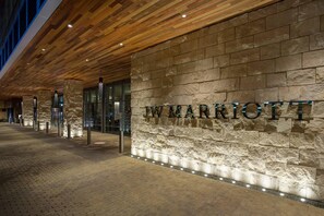 A hotel entrance with a stone facade and the name 'MARIE' illuminated.