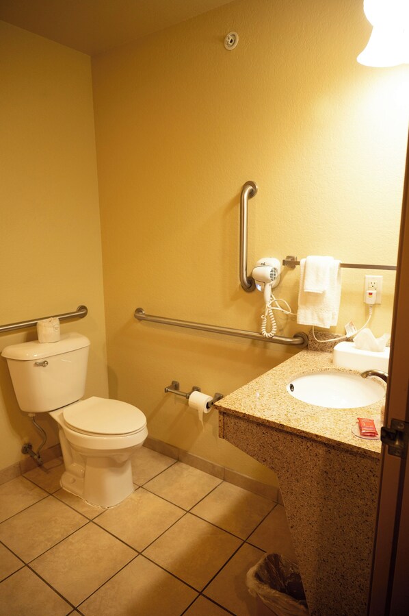 A bathroom with a toilet, sink, towel rack, and hand dryer.
