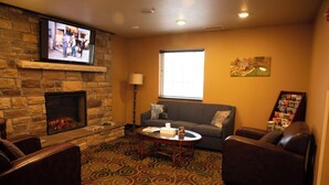A living room with a fireplace, a television mounted on the wall, a sofa, and a coffee table.