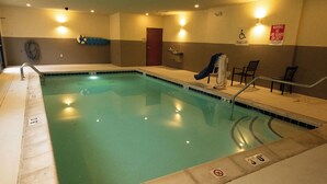 A swimming pool with a lifeguard chair, a pool lift, and a sign indicating no life guard on duty.