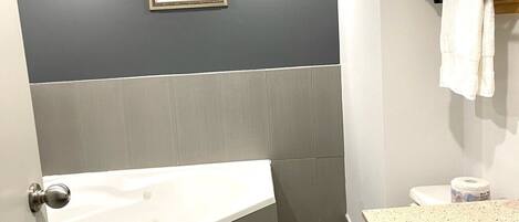Un baño moderno con bañera, inodoro y lavamanos.