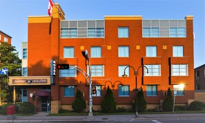 Stylish red brick building with a flat roof and symmetrical facade, featuring multiple windows and a prominent entrance.
