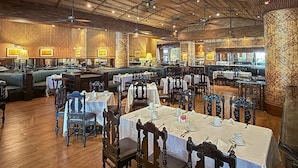 A spacious restaurant with high ceilings, wooden flooring, and a variety of seating arrangements including tables and booths. - Amarante Pyramids Hotel (Giza)
