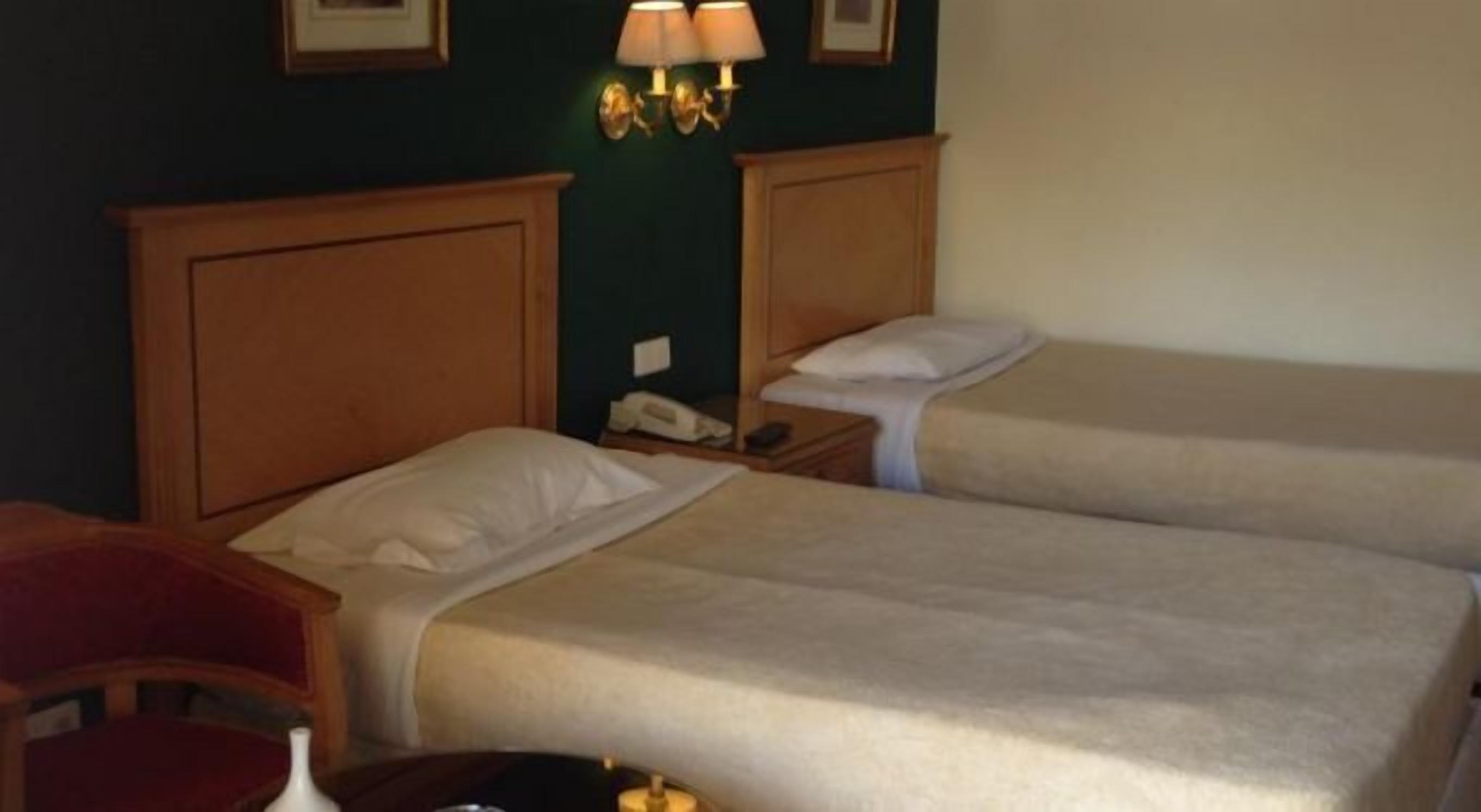 Habitació d'hotel amb dos llits, una taula i una cadira.
