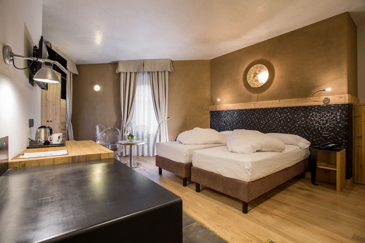 Deluxe driepersoonskamer | Een minibar, een kluis op de kamer, een bureau, geluiddichte muren