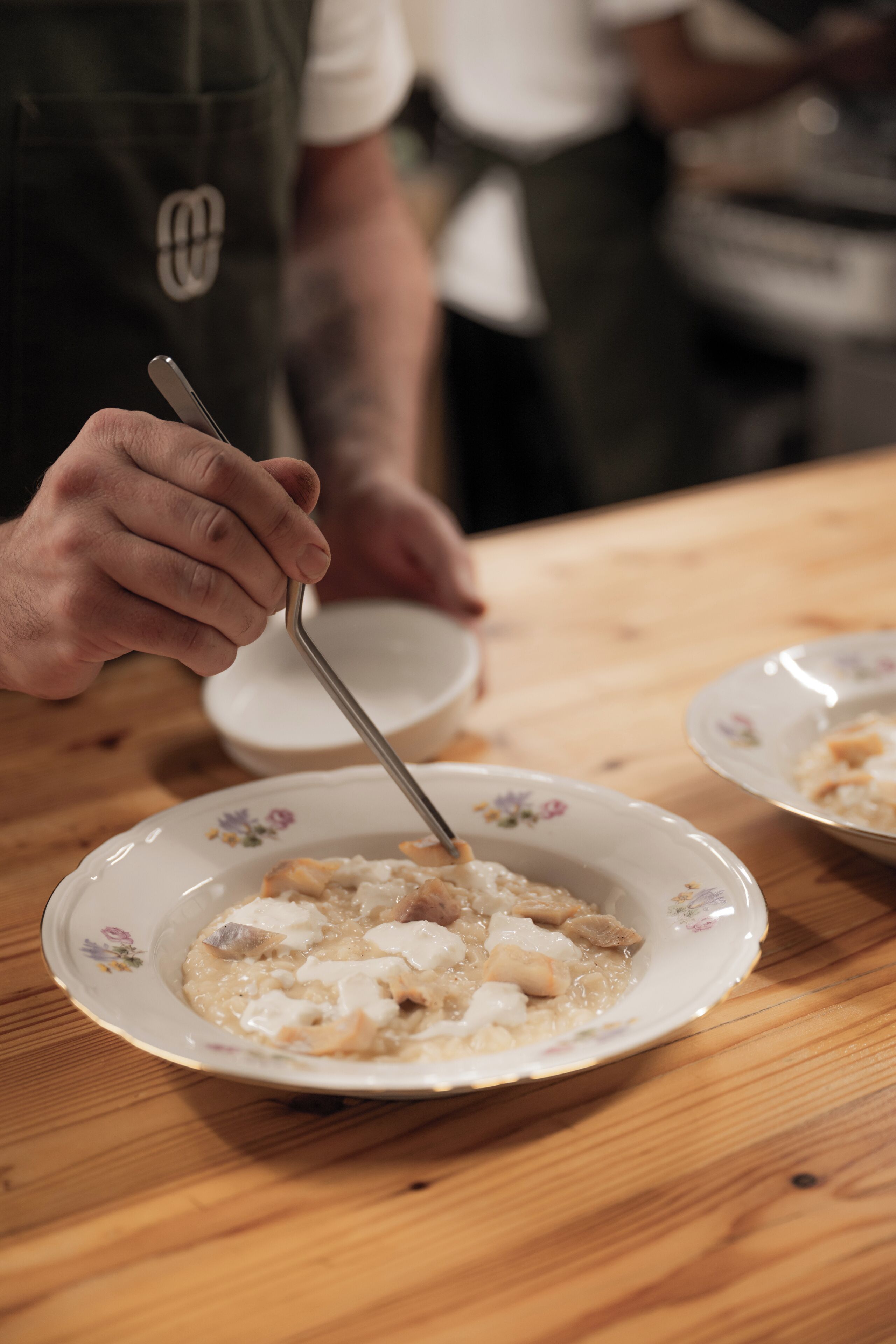 A person serving food from a bowl onto a plate.
