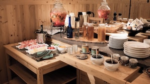 Montaje de bufé con diversos alimentos, salsas y bebidas.