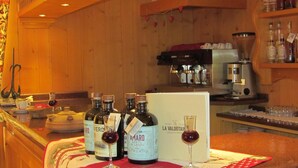 A bar area with bottles of wine, glasses, and a coffee machine. - Hotel Lysjoch (Gressoney-la-Trinite)