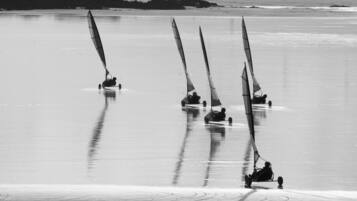 A beach with several sailboats.