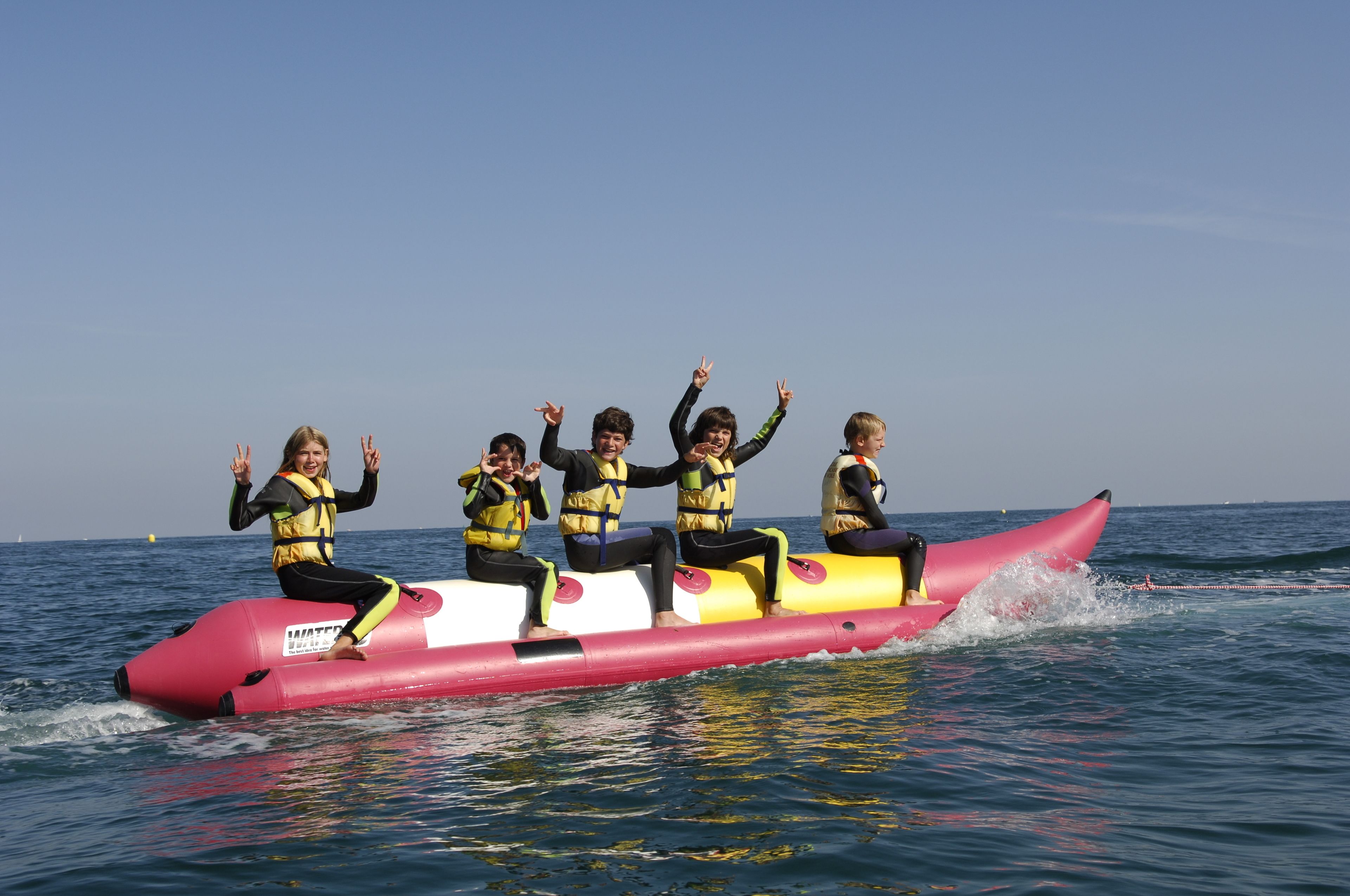 Un groupe de personnes sur un radeau gonflable rose, au milieu de l’océan.