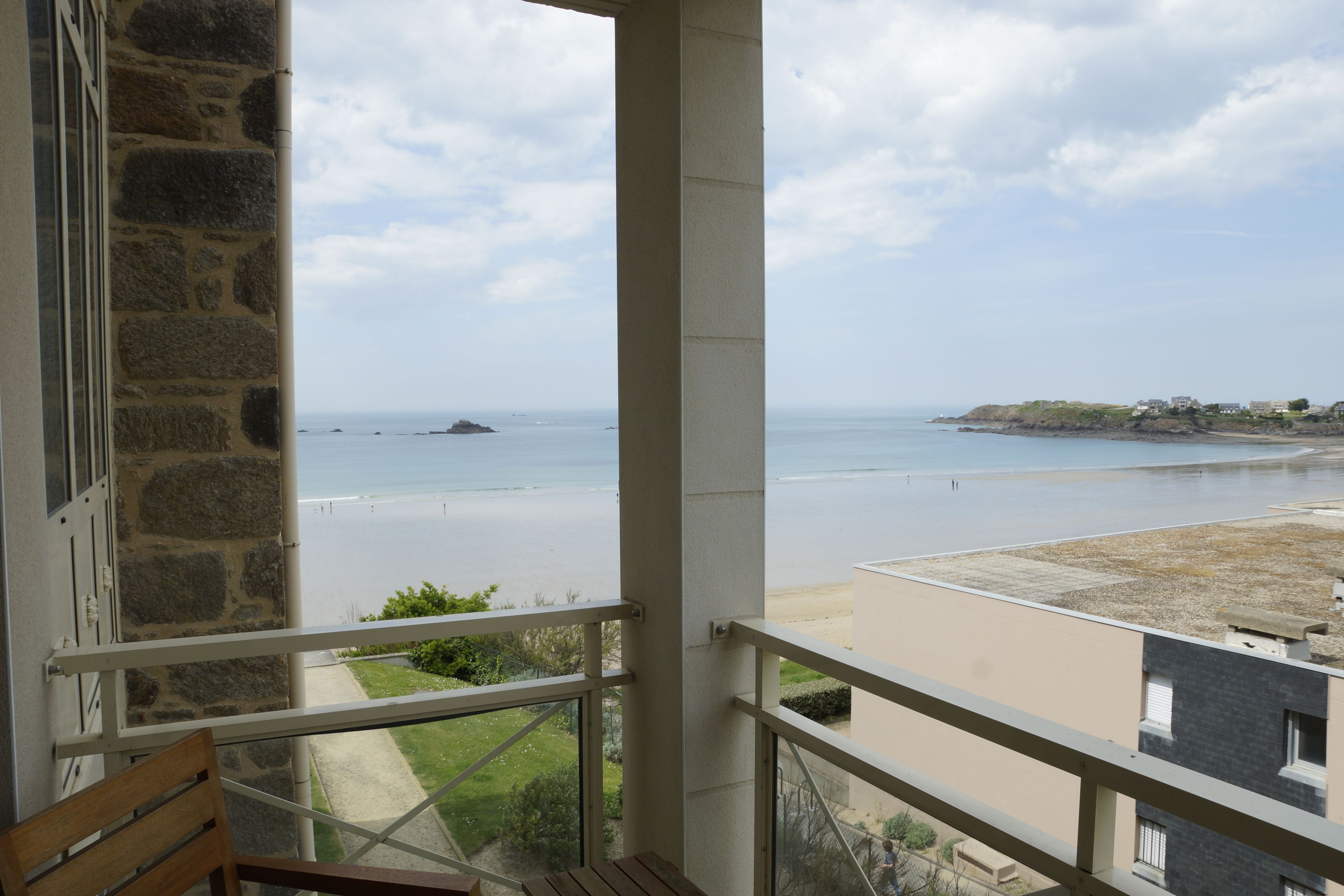 Uma varanda com vista para o mar e uma ilha ao longe.