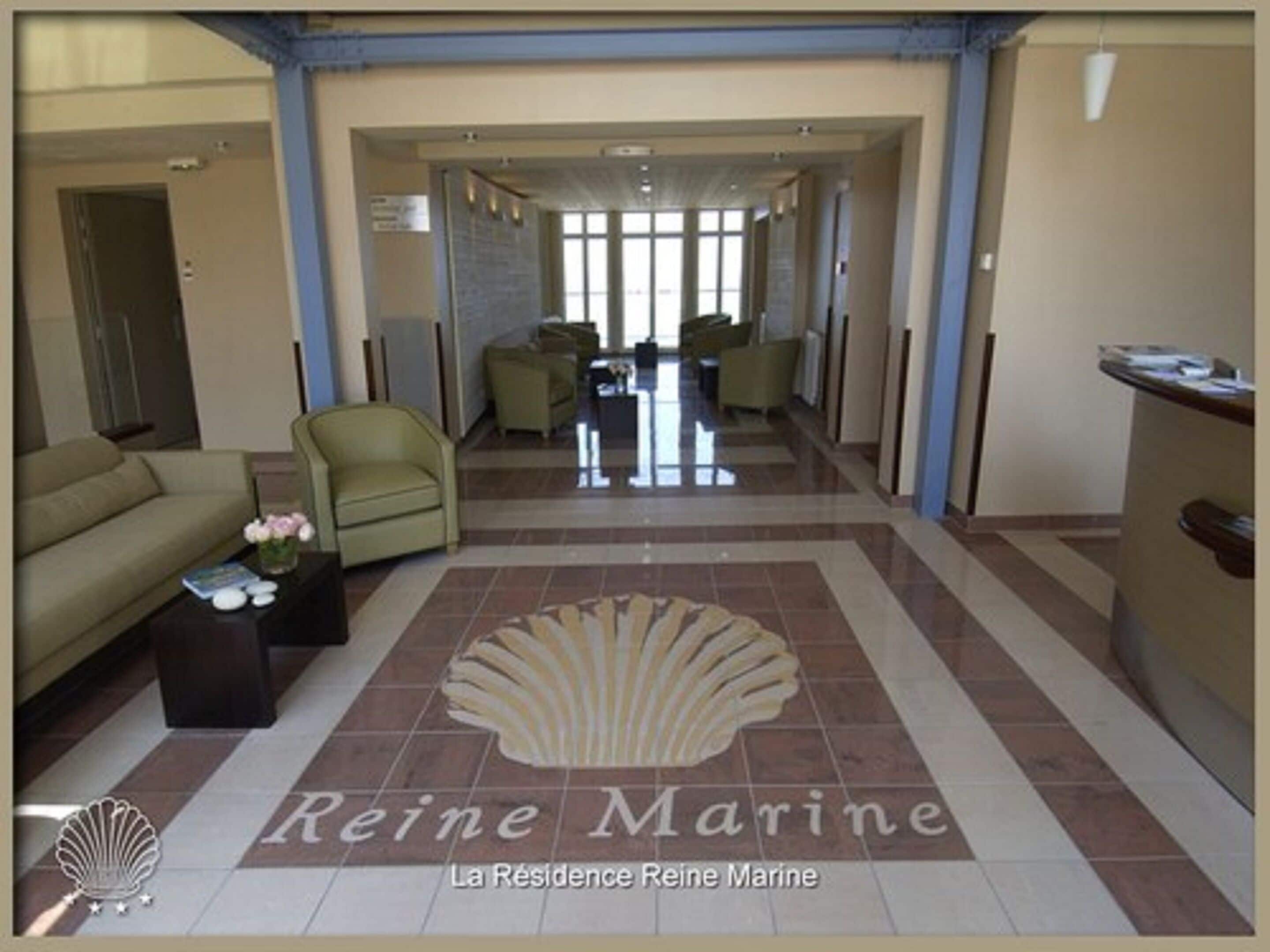 Un hall d’hôtel avec un comptoir d’accueil, un canapé et une table basse.