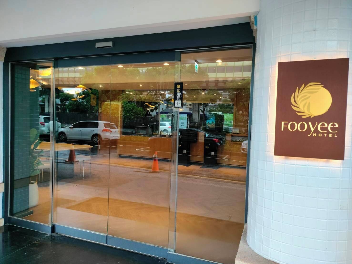 The entrance of the Foyyee Hotel with a glass door and a signboard.