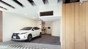 A modern interior with a white SUV parked in a spacious garage. - Fooyee Hotel Wenxinzq (Taichung)
