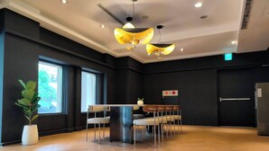 A spacious room with a wooden floor, a central table with chairs, and a large window providing natural light. - Fooyee Hotel Wenxinzq (Taichung)