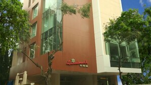 A Landmark hotel with a modern design, featuring a prominent glass facade and a mix of beige and brown exterior colors. - Landmark Residency (Mumbai)