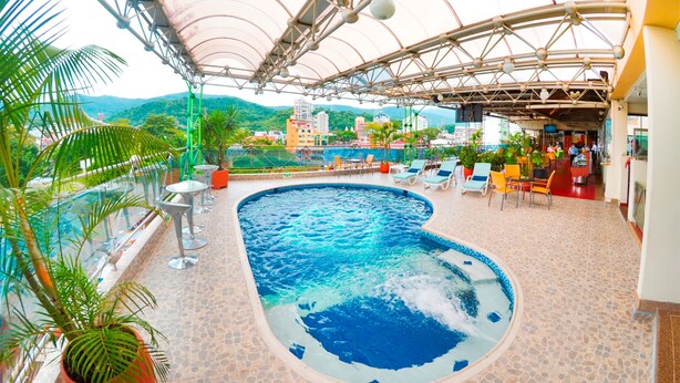 A rooftop pool with a view of the city and mountains.