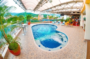 A rooftop pool with a view of the city and mountains.