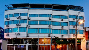 A multi-story hotel with a flat facade, large windows, and air conditioning units.