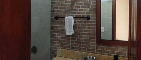 A bathroom with a toilet, sink, and a mirror.
