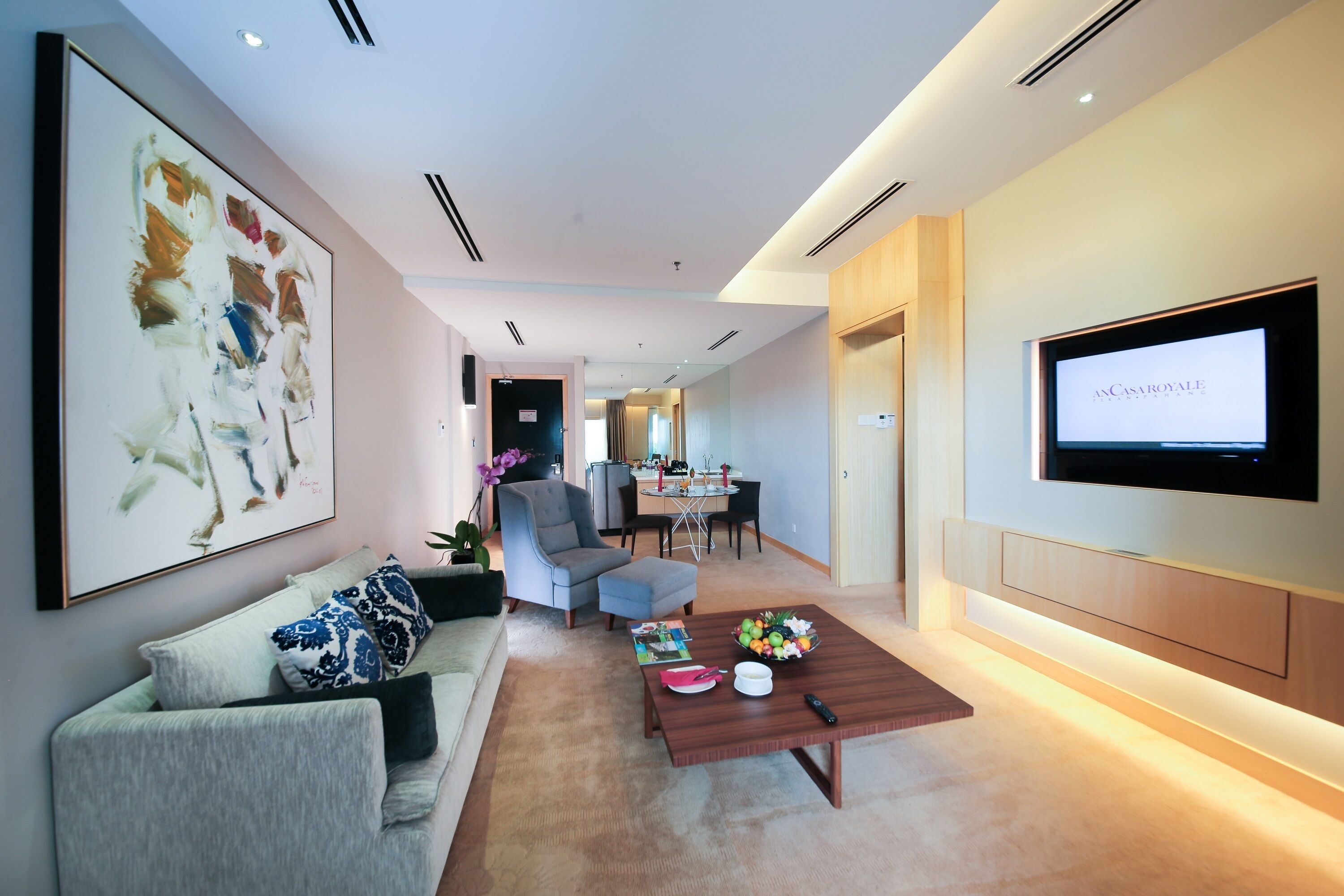 A modern living room with a sofa, coffee table, and artwork on the wall.