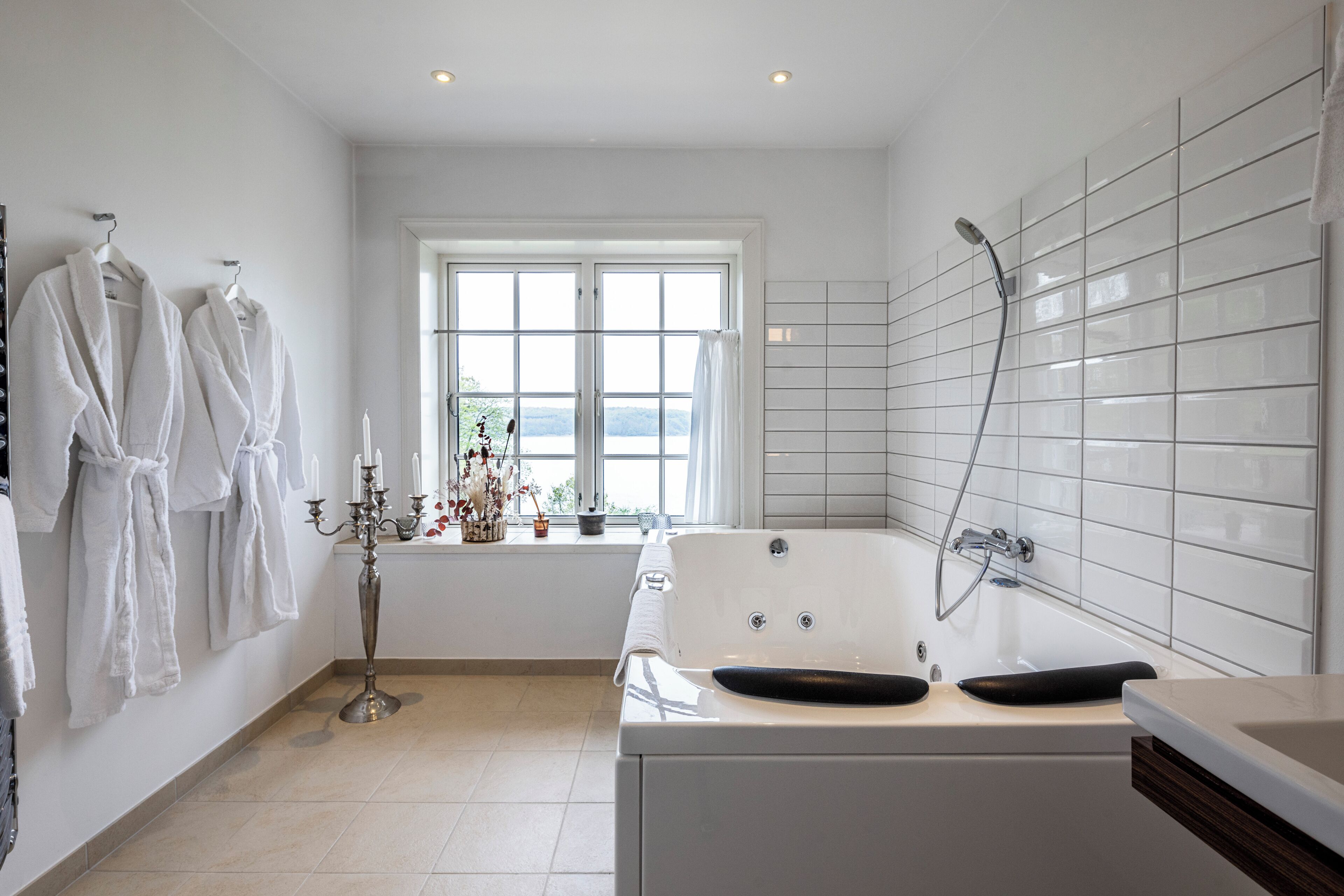 Ein modernes Badezimmer mit einer Badewanne, einer Dusche und einem Fenster mit Blick.