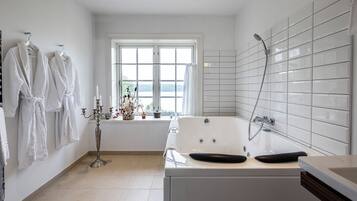 Un bagno moderno con una vasca, una doccia e una finestra vista.