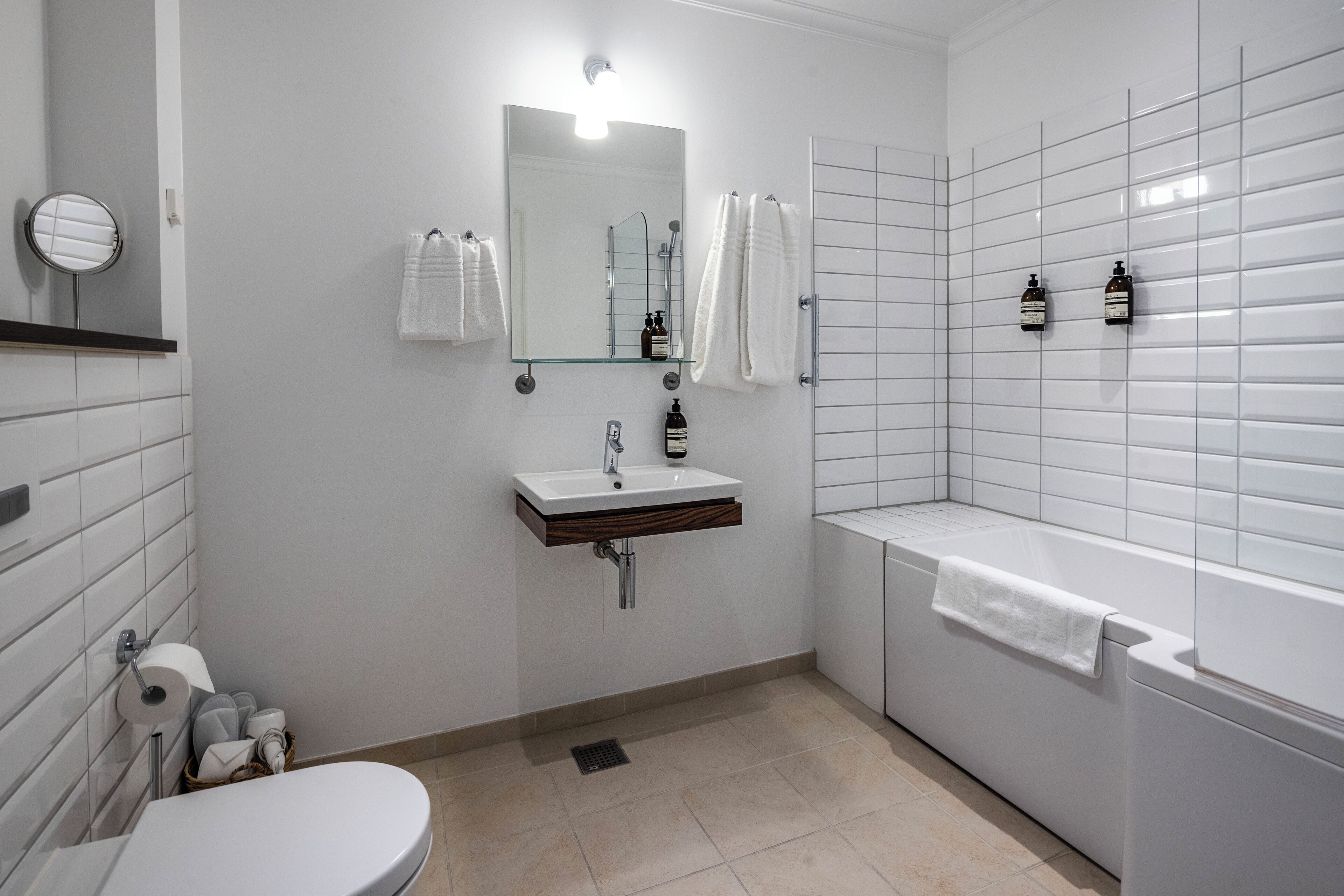 Une salle de bain moderne équipée de toilettes, d’un lavabo, d’un miroir et d’une baignoire.