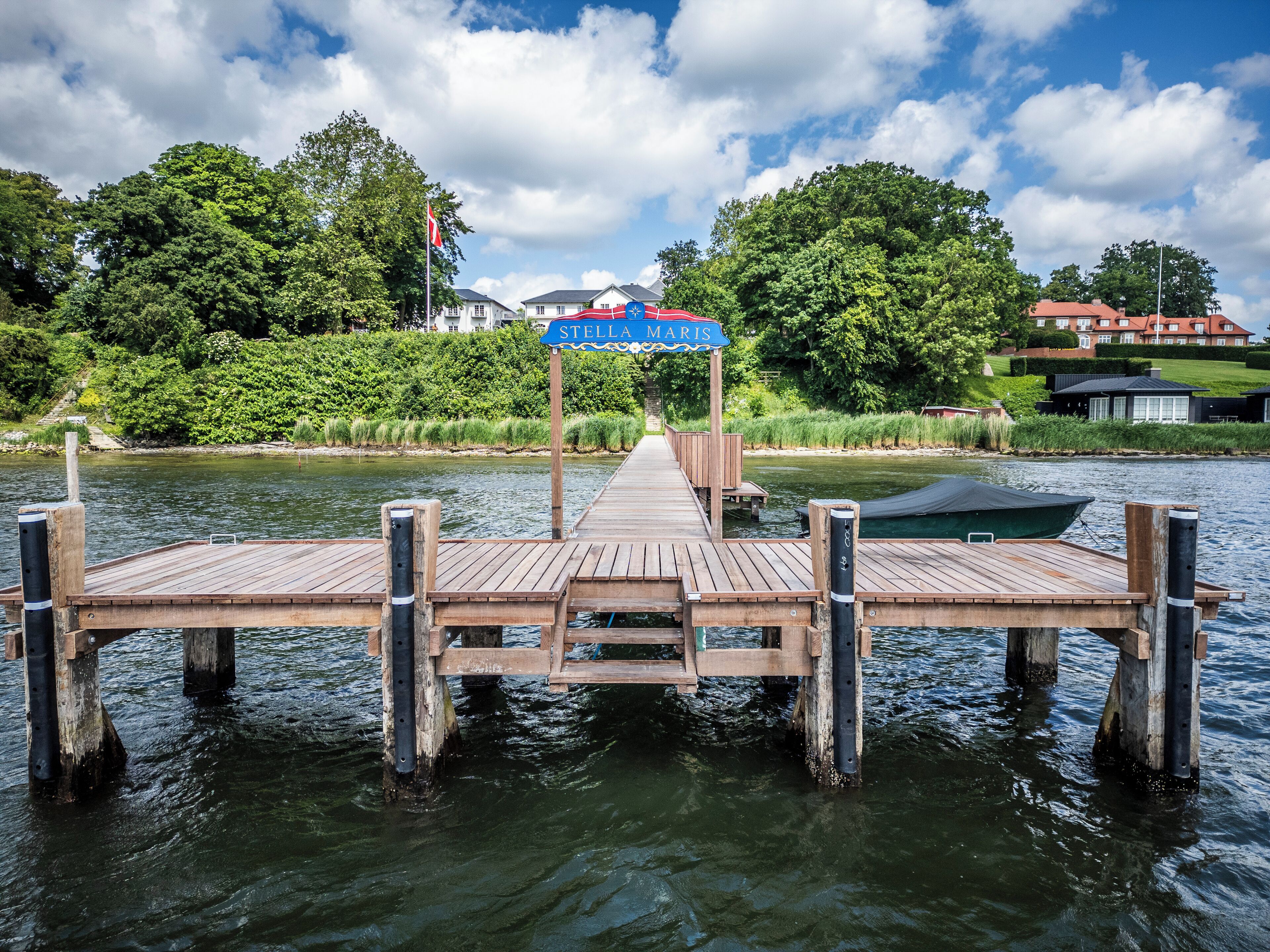 Un muelle de madera que se adentra en un cuerpo de agua, con un letrero que dice 'STELLA MARIS'.