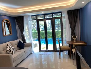 Suite, 1 cama de matrimonio grande, acceso a la piscina, vistas a la piscina | Zona de estar | Televisión LCD de 42 pulgadas con canales por cable, una televisión