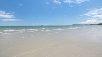Una playa cerca, arena blanca, toallas de playa