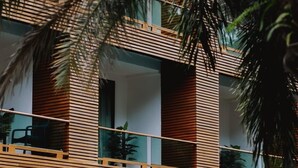 Een modern gebouw met horizontale houten lamellen, grote ramen en balkons.