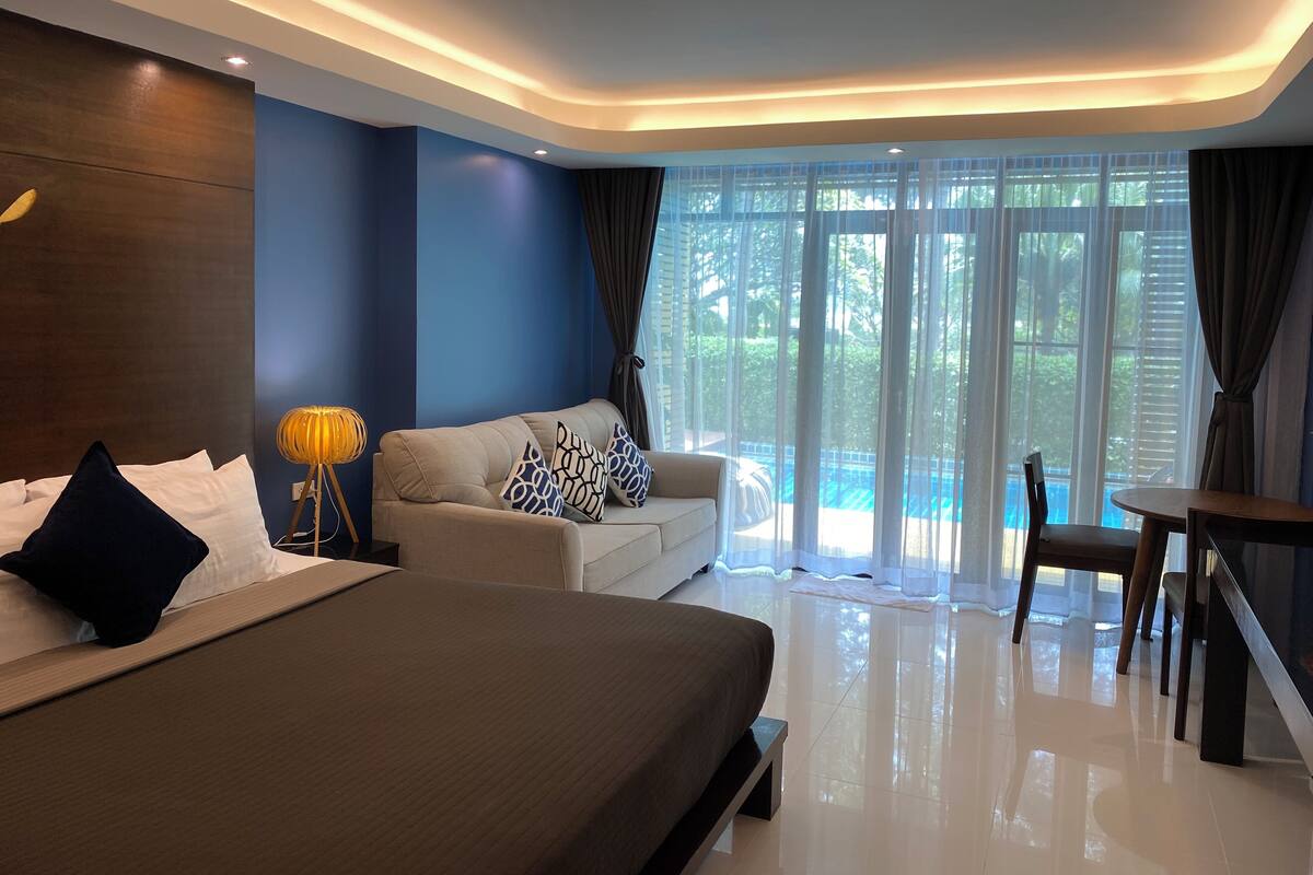 Une chambre d’hôtel moderne avec un grand lit, un canapé et une table à manger.