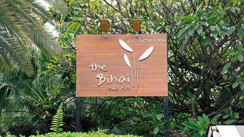 A wooden sign with the text "the Bihai Hua Hin" and two lanterns.