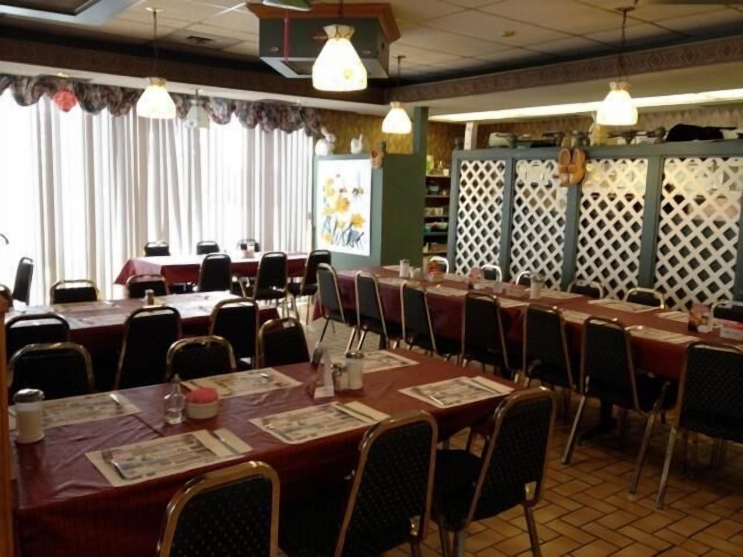 A conference room with long tables and chairs, a whiteboard, and a decorative lattice partition.