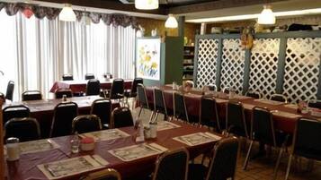 A conference room with long tables and chairs, a whiteboard, and a decorative lattice partition.