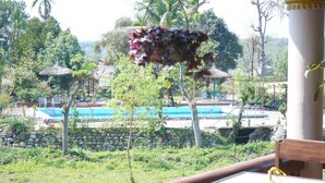 Vista de una zona de piscina con un muro de piedra y sillas de descanso.