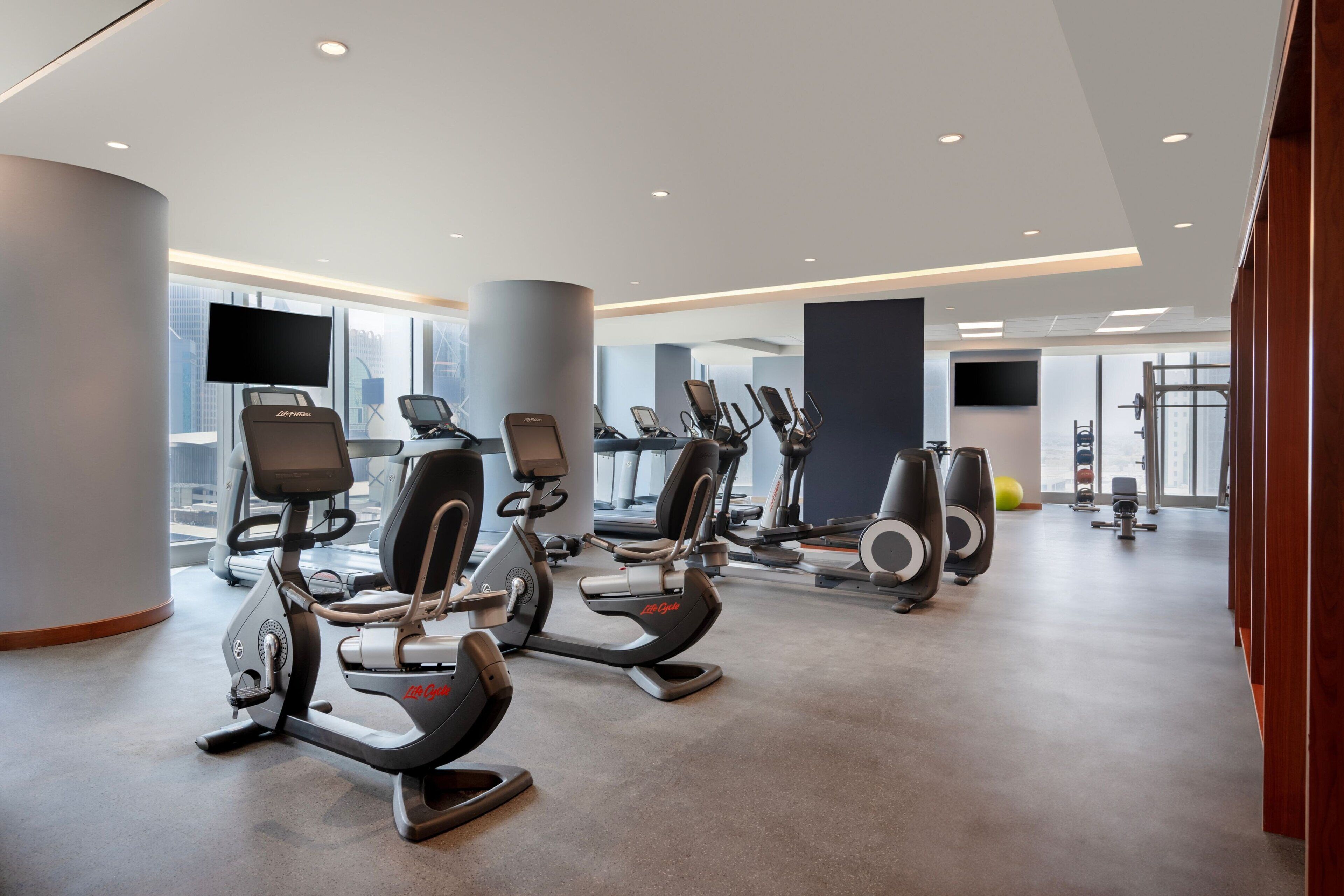 A modern gym with stationary bikes, treadmills, and exercise balls.