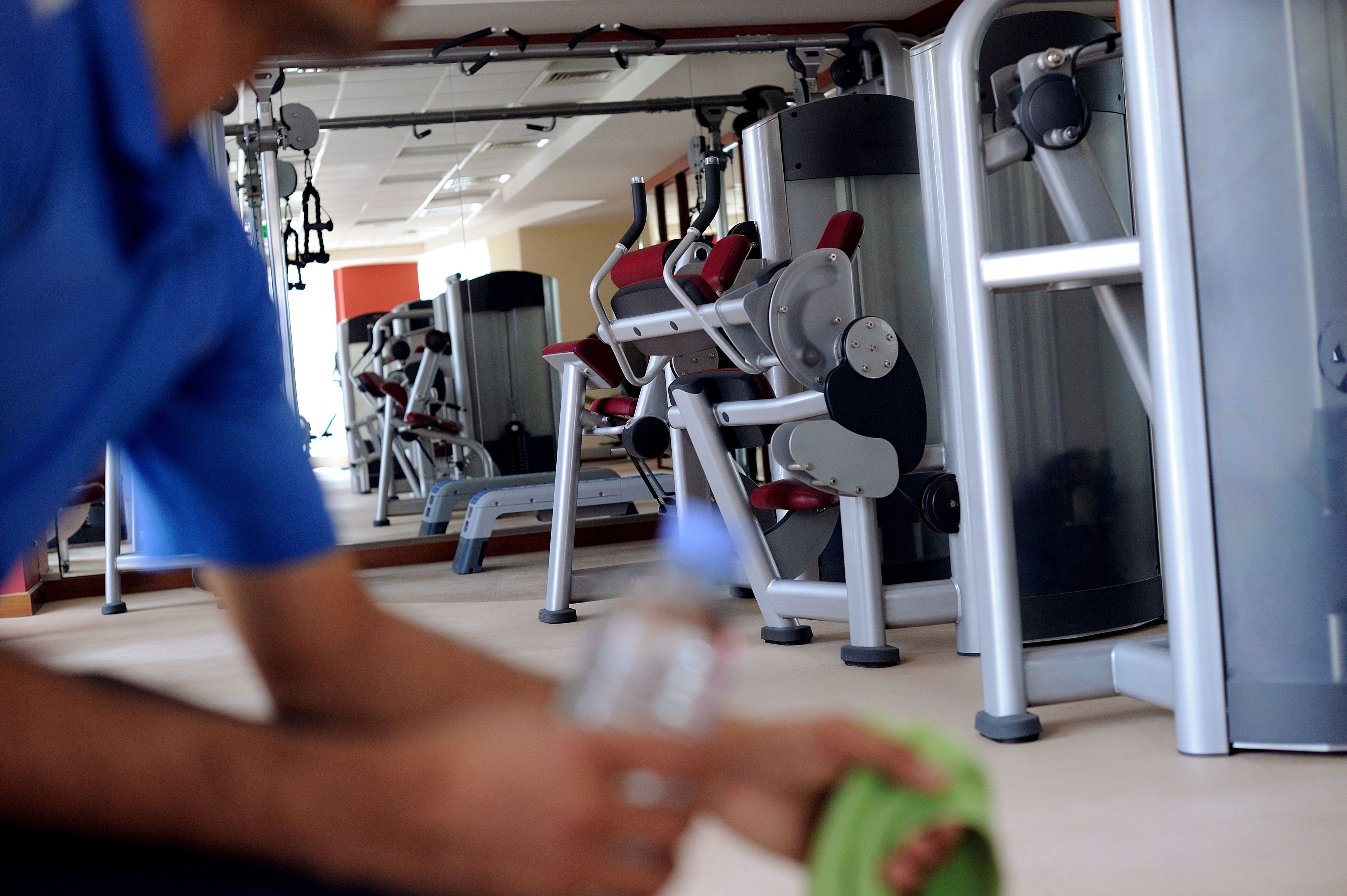 A gym with various exercise equipment, including a bench press and weight machines.