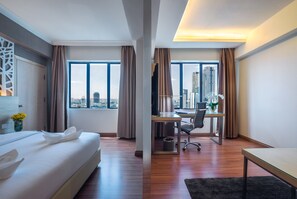 A modern hotel room with a bed, desk, and large windows offering a city view. - Crystal Crown Hotel Petaling Jaya (Petaling Jaya)