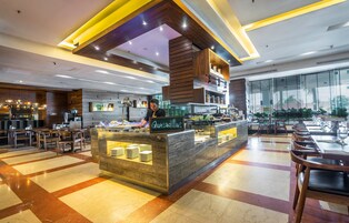 A modern restaurant with a central counter labeled 'Quesadillas', surrounded by tables and chairs.