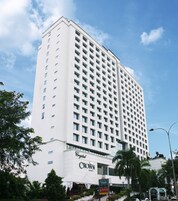 Un hotel alto y blanco con una cuadrícula de ventanas y un letrero que dice "Crystal Crown Hotel".