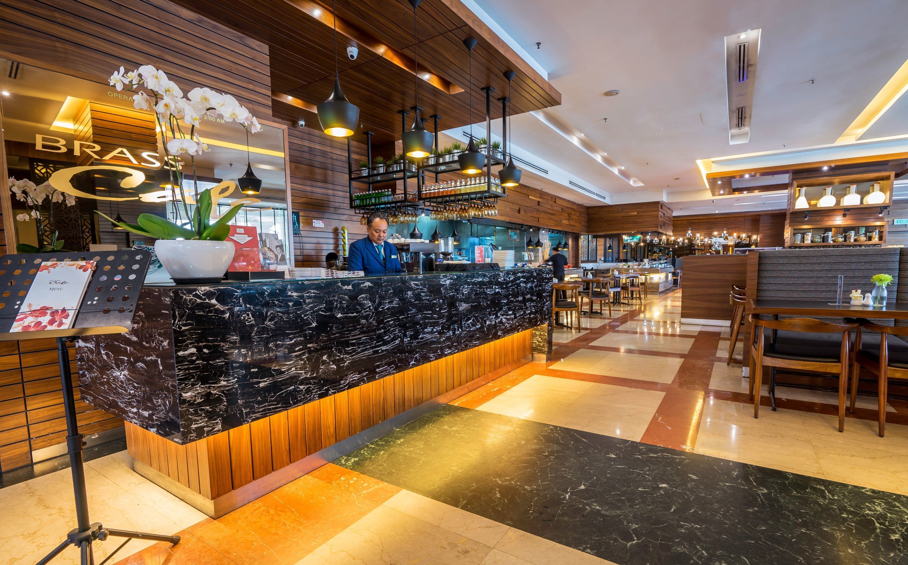 Un moderno vestíbulo de hotel con mostrador de recepción de mármol, detalles de madera e iluminación ambiental.
